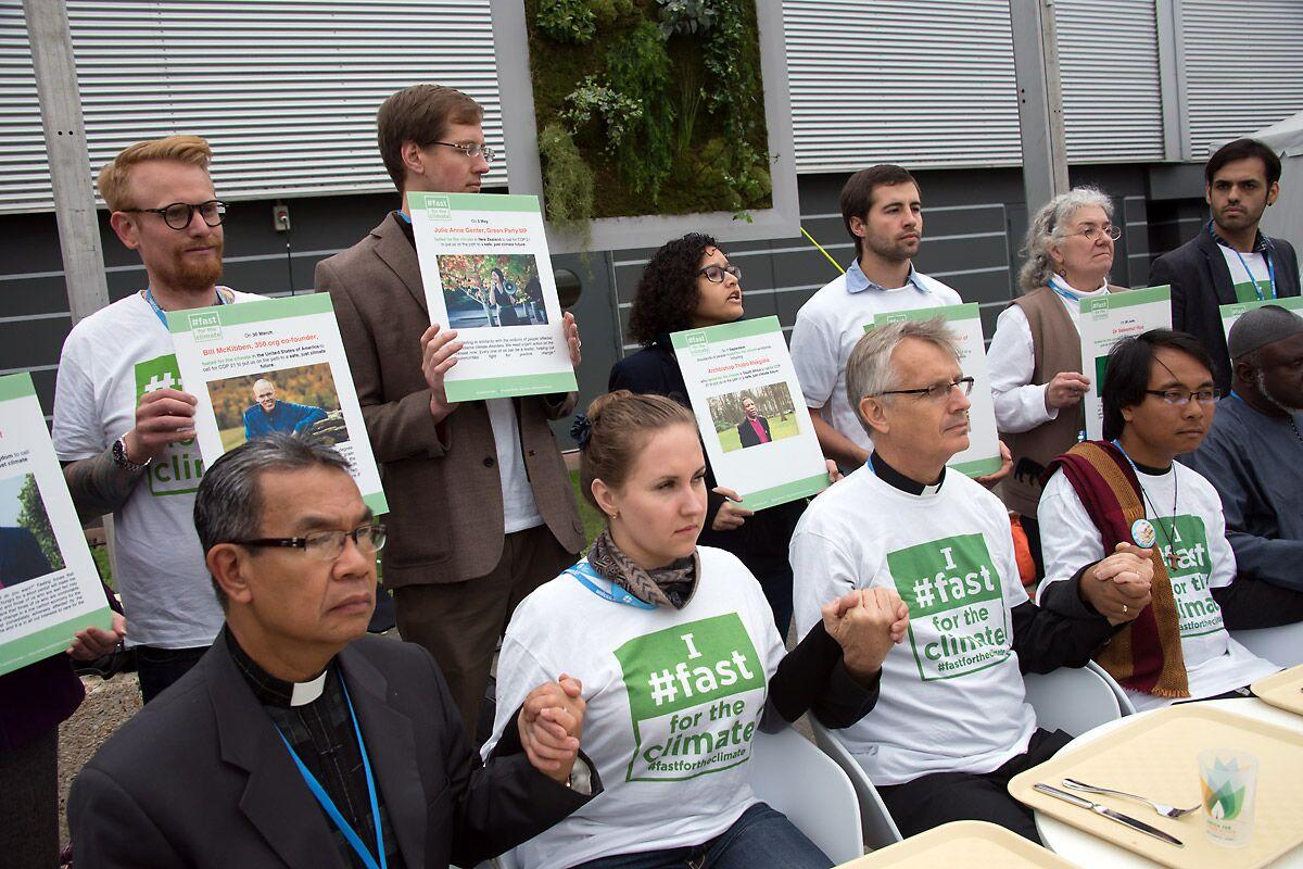 Eine interreligiöse Gruppe vor leeren Tablets bei einer Demonstration während des Klimagipfels in Paris 2015. Foto: LWB/Ryan Rodrick Beiler