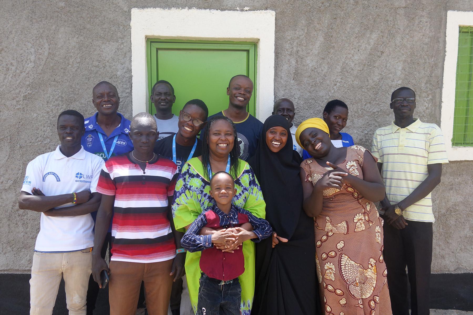 Bewohnerinnen und Bewohner des Flüchtlingslagers Kakuma im Nordwesten Kenias kommen für ein Gruppenfoto zusammen, nachdem sie an einem vom LWB geleiteten Workshop teilgenommen haben, um Gedichte für das Büchlein „I am Hope“ zu schreiben. Jackline Irankunda steht in der ersten Reihe ganz rechts. Foto: LWB/P. Schnoebelen