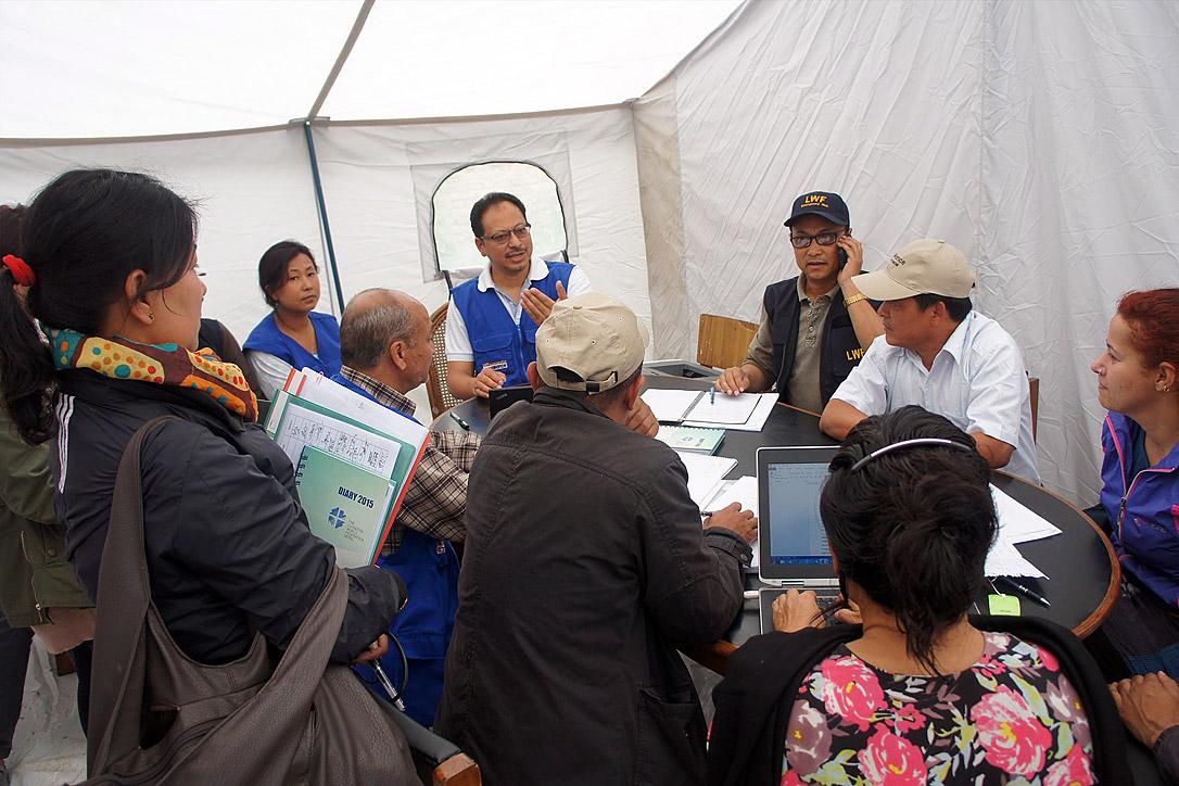 Der LWB-Landesdirektor für Nepal, Dr. Prabin Manandhar (in der Mitte mit blauer Weste), auf einer Teambesprechung zur Koordinierung des Hilfseinsatzes des LWB nach dem Erdbeben. Foto: LWB/C. Kästner