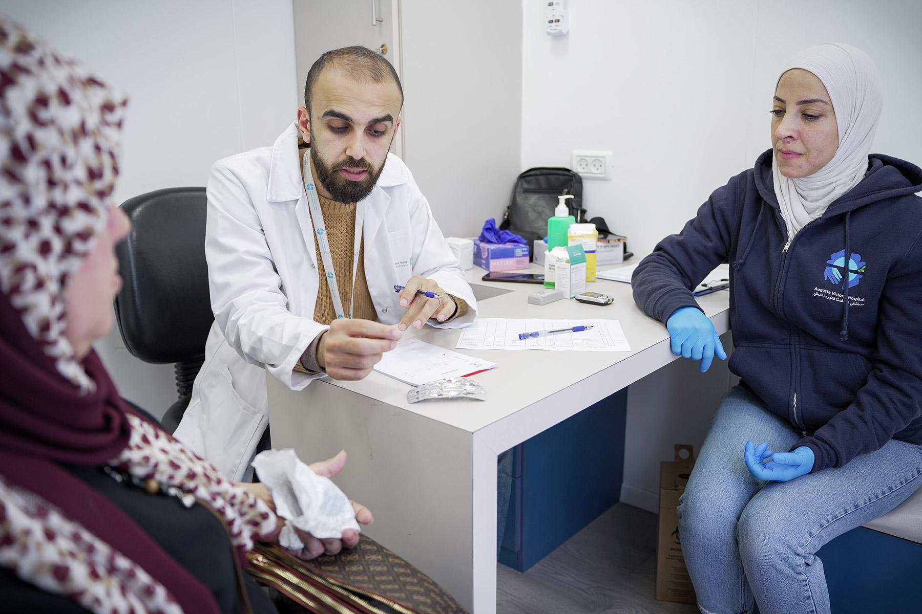 Dr Maen Hay Ahmed (center) and nurse Reena Abu Sneineh (right) during consultation in the mobile diabetes unit. Photo: LWF/ Abdalla Elayyan