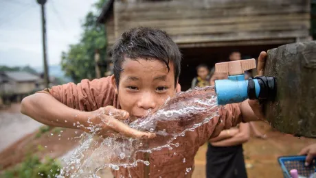 A young boy drinks from a well installed by the LWF in the Viengphoukha District, Laos. Photo: LWF/Thomas Lohnes.