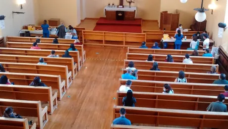 El equipo de salud encargado de las aplicaciones se encuentra a un costado del altar, mientras que la gente aguarda su turno de vacunación en los bancos de la iglesia. Foto: Miguel Ángel Nuñez.