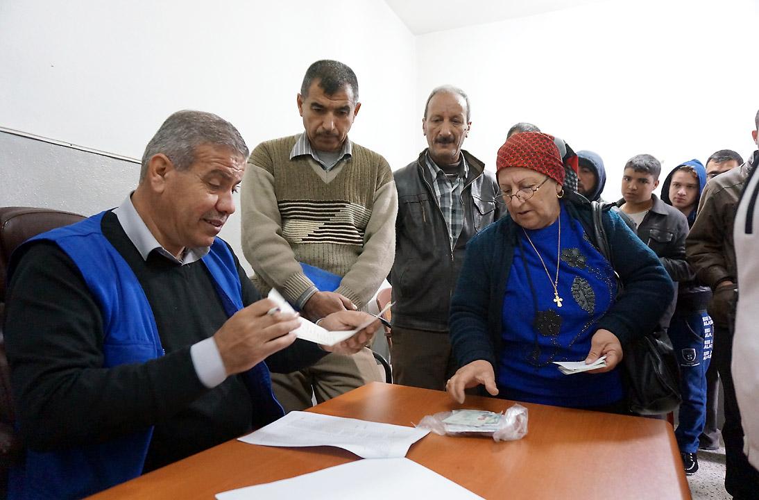Gorgya Paols, 63, receives a LWF food voucher, entitling her to a carton of food that will last a month. Despite the violence she fled in 2005 and the worsening situation since the ISIS insurgency, her single wish is for peace in Iraq. Photo: LWF/S. Cox