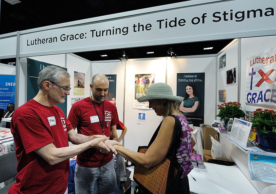Volunteers offer a visitor a temporary tattoo at the 