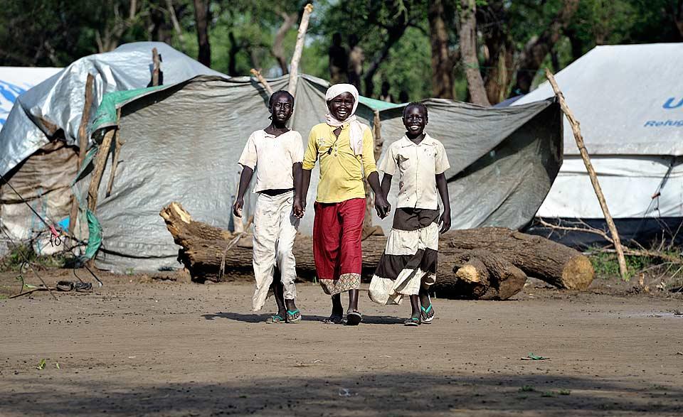 Haram Jukin (center) walks with two of her friends in Yusuf Batil refugee camp in South Sudan's Upper Nile State. Â© Paul Jeffrey