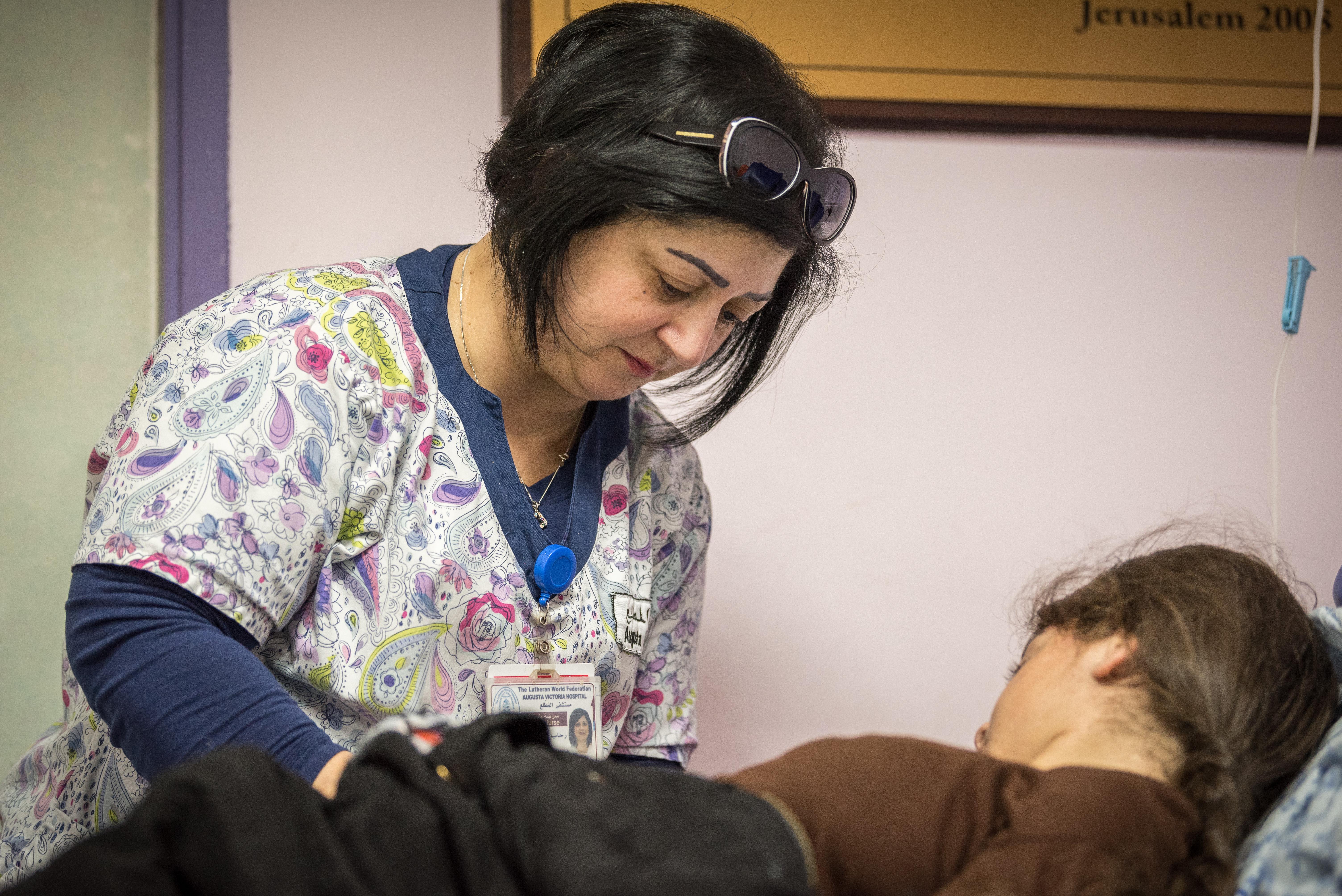 Rihab George, leitende Krankenschwester in der Ambulanz des Augusta-Victoria-Krankenhauses, behandelt eine junge Patientin. Das Krankenhaus bietet Menschen aus Palästina eine spezialisierte Behandlung an, die ihnen anderswo nicht zur Verfügung steht. Foto: LWB/Albin Hillert