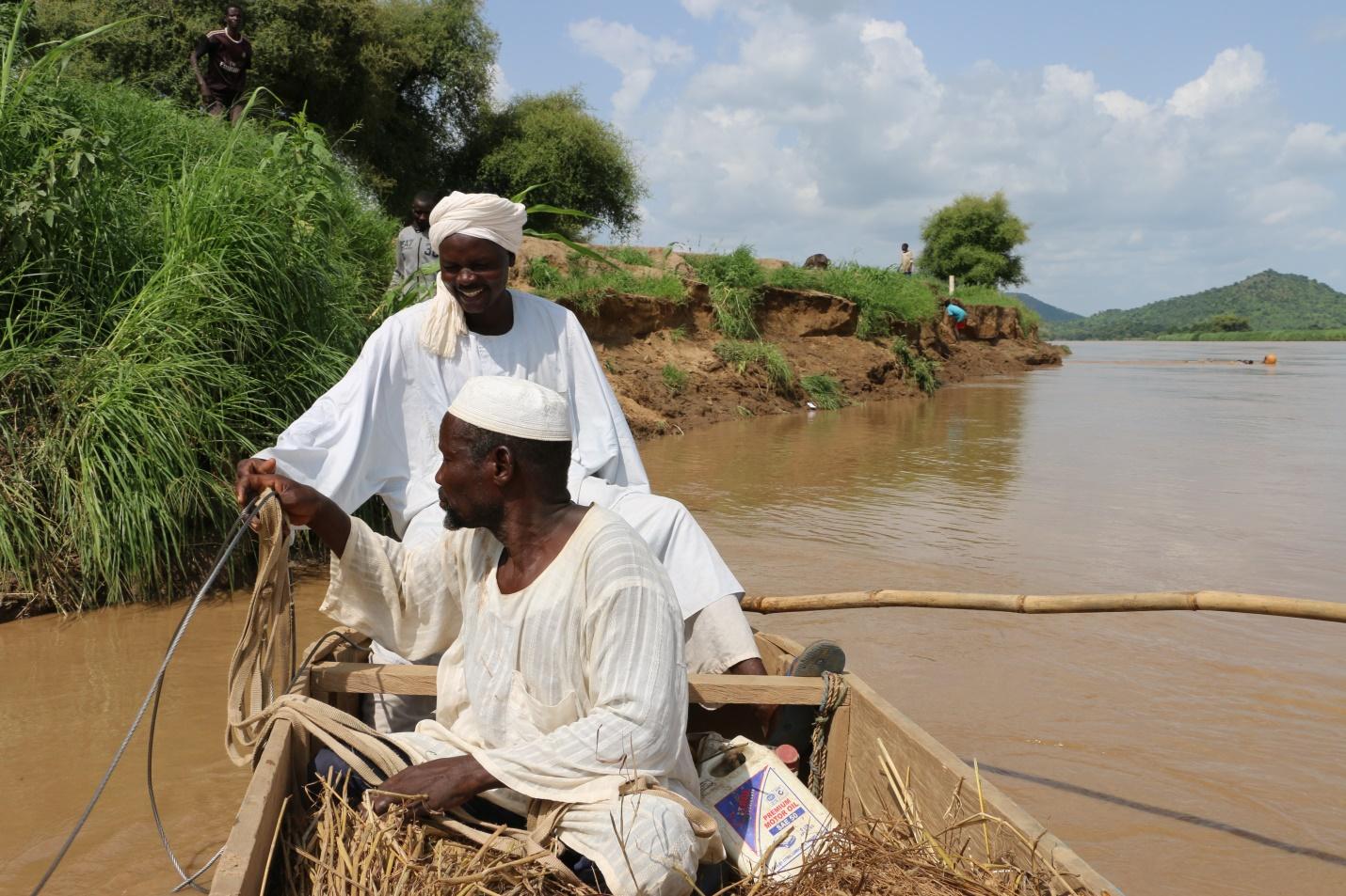 Djouma Ousmane (hinten) bringt Mitglieder seiner Dorfgemeinschaft mit einem Fährboot über den Fluss, das seine Gruppe mit gemeinschaftlich im Rahmen einer LWB-Initiative erwirtschaftetem Geld gekauft hat. Foto: LWB Tschad