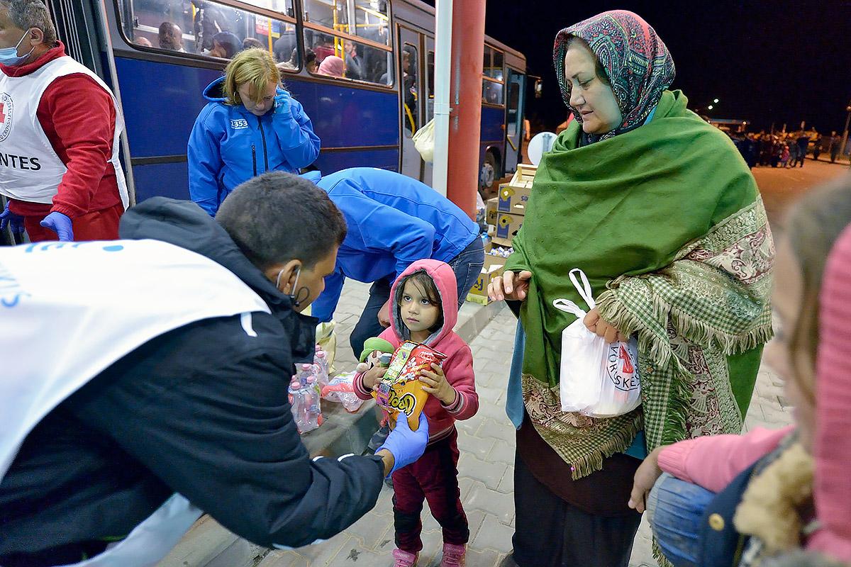 Mitarbeitende der Hungarian Interchurch Aid, einem Mitglied der ACTAlliance, kümmern sich um neu angekommene Flüchtlinge an der Grenze zwischen Ungarn und Kroatien. Hunderttausende durchquerten Ungarn in 2015, um von Syrien, Irak und anderen Ländern nach Westeuropa zu gelangen. Foto: Paul Jeffrey/ACT