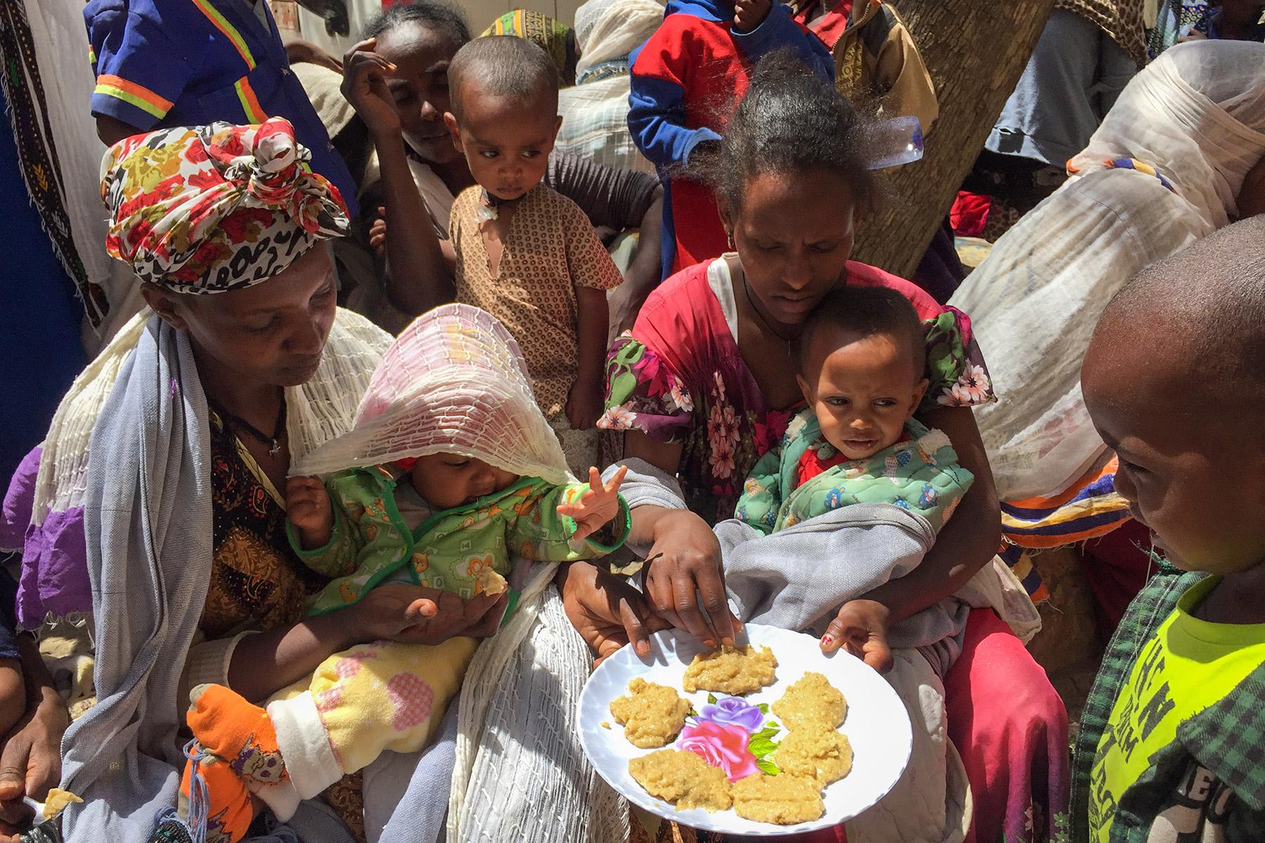 People taste the pancakes made in a cooking distribution with the enriched âFamixâ flour, distributed to displaced people in Tigray. All photos: LWF/ S. Gebreyes 