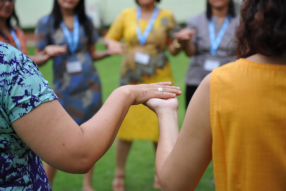 Women from LWF member churches in Asia take part in an exercise, holding hands. Photo: LWF/A. Danielsson