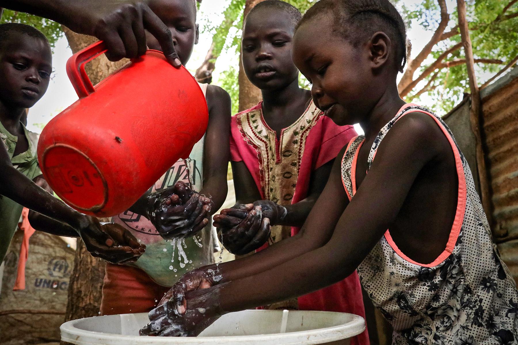 Children demonstrate hand washing at Kakuma refugee camp, Kenya. The LWF is the main implementer of education in the camp, and awareness-raising on hygiene is part of that work. The LWF has reinforced hygiene education to prevent the spread of COVID-19 in the camp. Photo: LWF/P. Omagwa