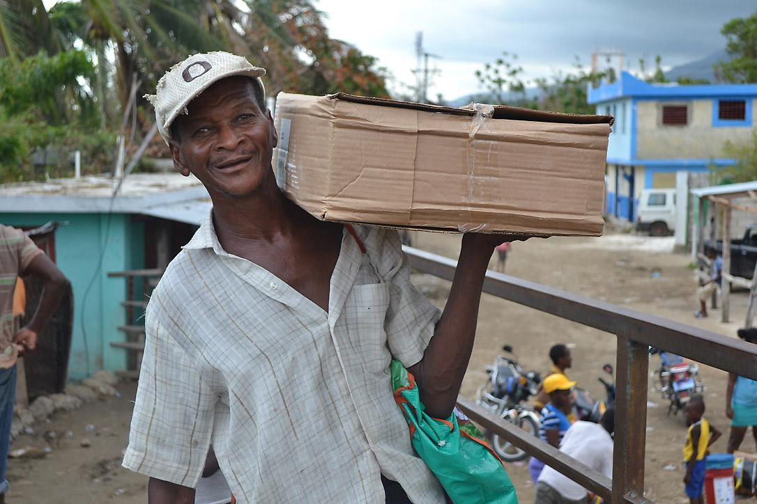 A man receives a shelter kit in a joint LWF/Diakonie Katastrophenhilfe distribution in Petit Goave. Photo: LWF Haiti