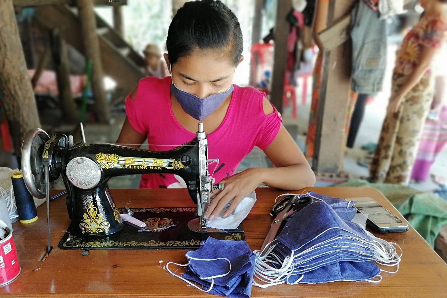 Eine Unternehmerin im Dorf Kyauk Tan Gyi im Distrikt Sittwe im Bundesstaat Rakhine in Myanmar näht Gesichtsmasken aus Stoff. Foto: LWF/Nu Nu Aye