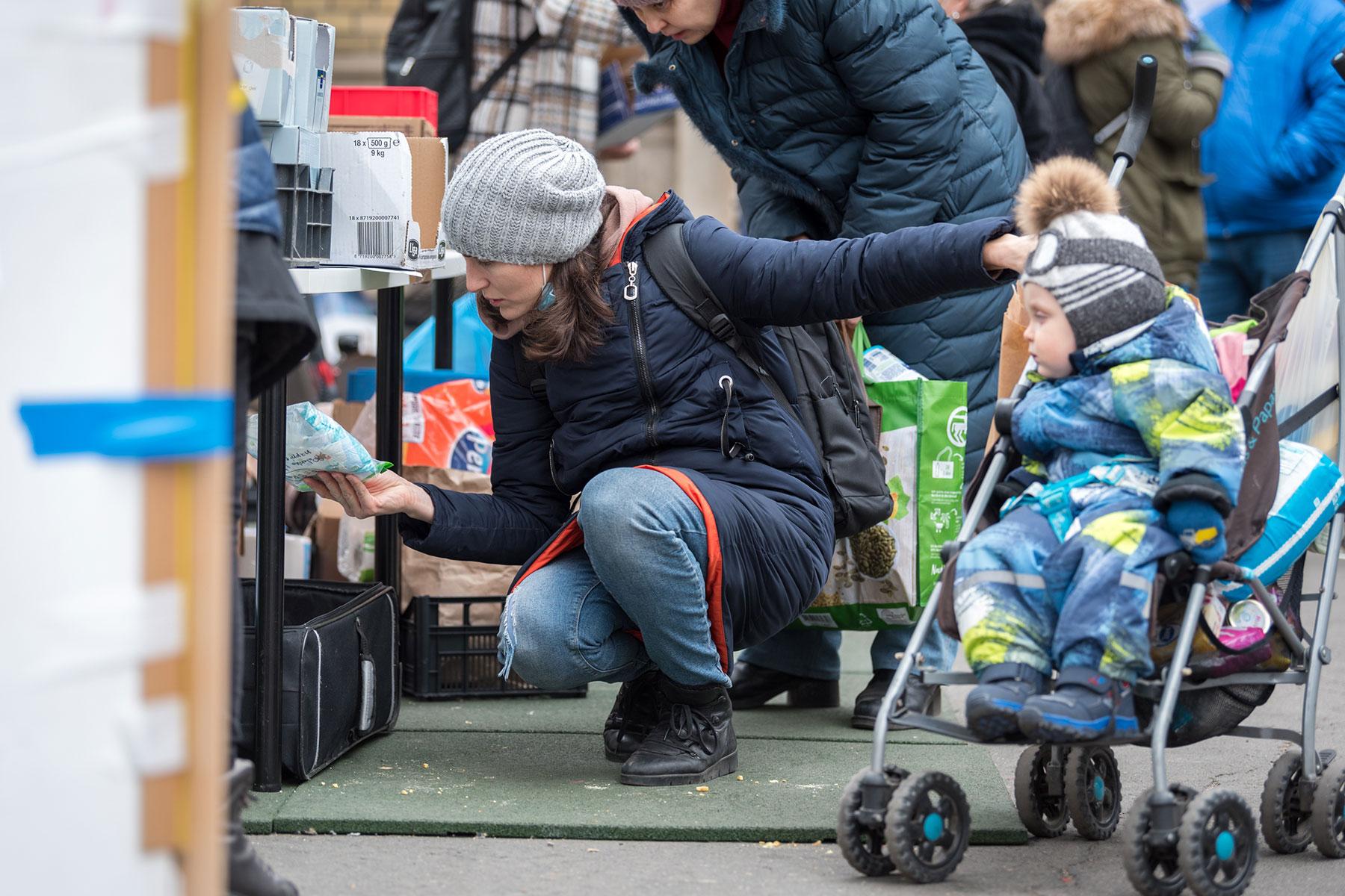 Ukrainian refugee woman Alona looks at supplies at one of the aid workersâ stands at Nyugati train station in Budapest. Alona, her 1.5-year-old son, and her mother arrived from Ukraine on 6 March, following a 26-hour long journey from the capital city Kyiv. All photos: LWF/Albin Hillert