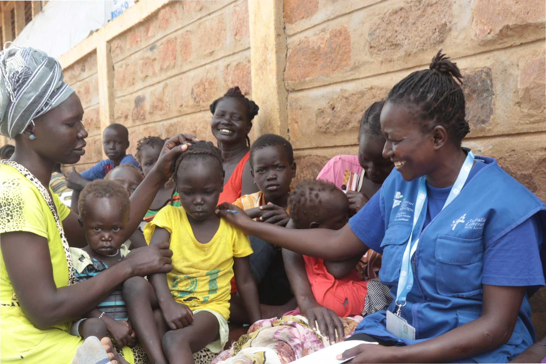 Sarah Ewoi, with a South Sudanese refugee family at Nadapal center. Photo : LWF Kenya