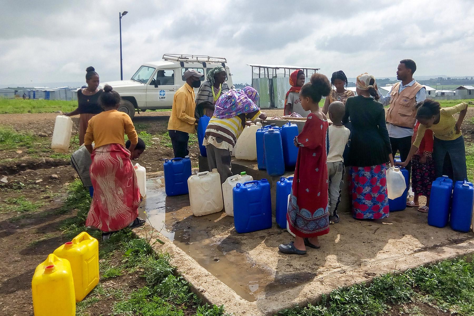 Binnenvertriebene holen Wasser an einer Pumpe im Seba Kare IDP-Lager bei Mekelle. Der LWB hat in dem Lager, das zuvor durch Wassertransporte mit Wasser versorgt wurde, ein Pumpsystem eingerichtet. Foto: LWB/T. Debessu