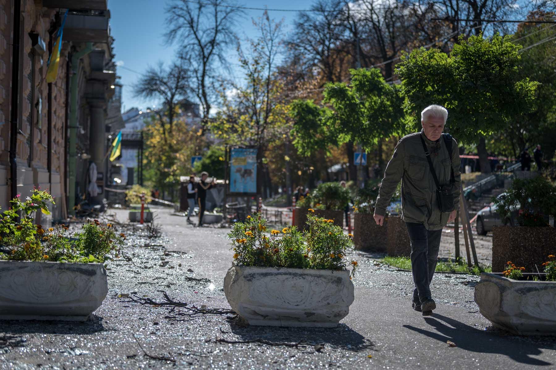 10 October 2022, Kyiv, Ukraine: A man walks through the rubble and shards of glass on the street of Vulytsya Tereshchenkivsʹka in central Kyiv, which hours earlier was hit by a Russian missile. Photo: LWF/ Albin Hillert