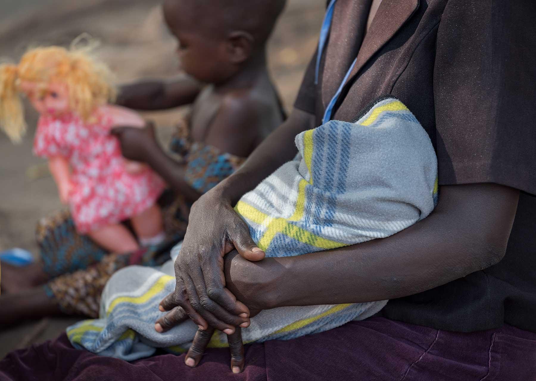 Eine Frau mit ihren Kindern im Iboa-Gesundheitszentrum im Obongi-Distrikt in Norduganda, wo der LWB und Medical Teams International mangelernährte geflüchtete Kinder und ihre Mütter unterstützen
