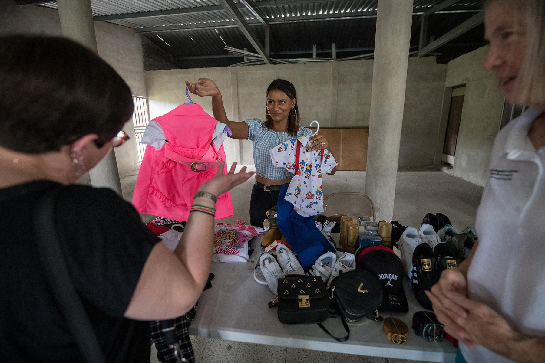 26 October 2023, El Guante, Cedros, Honduras: Alexandra Ochoa from Guaimaca, one of a group of youth receiving support from the Lutheran World Federation World Service program, displays articles of clothing she intends to sell as part of her small-scale business. Photo: LWF/A. Hillert