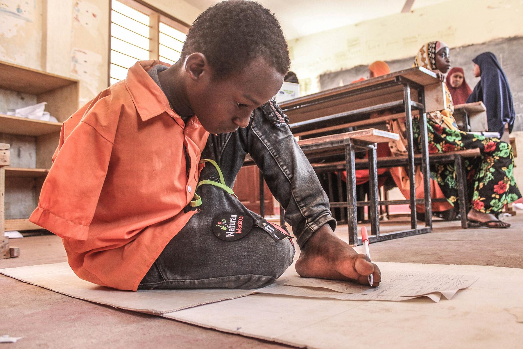 Mohamed has learned to draw with his feet. Photo: LWF/ N. Tado