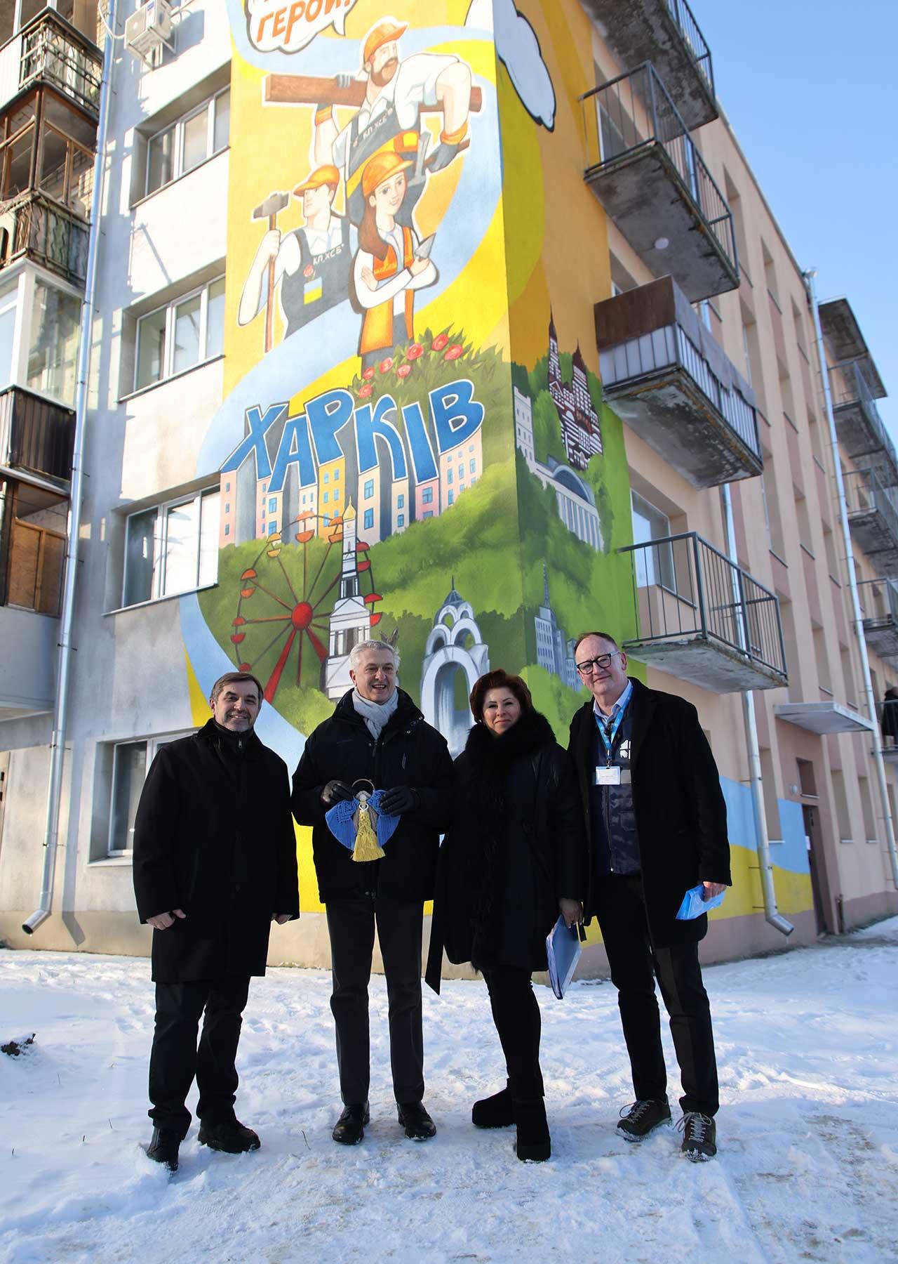 LWF team leader Mark Mullan with UNHCR High Commissioner Filippo Grandi (center) , in front of a mural of rebuilding heroes. Photo: LWF/ Anatolyi Nazarenko