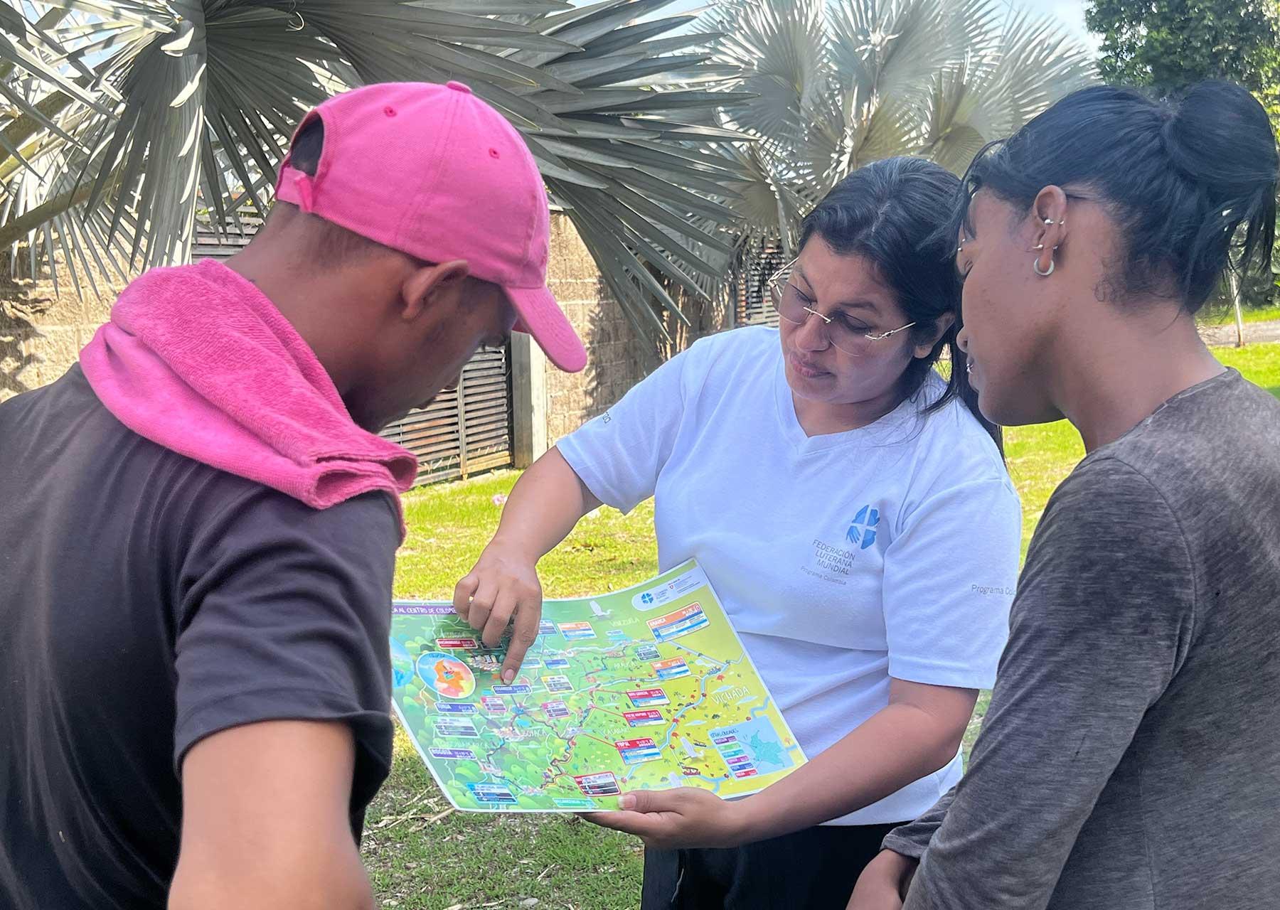 Eine LWB-Mitarbeiterin erklärt, wo Migrierende aus Venezuela Hilfe finden können. Die Karte der Arauca-Casanare-Schutzroute wurde vom LWB-Kolumbien in Venezuela mit Unterstützung der Schweizer Botschaft entwickelt.