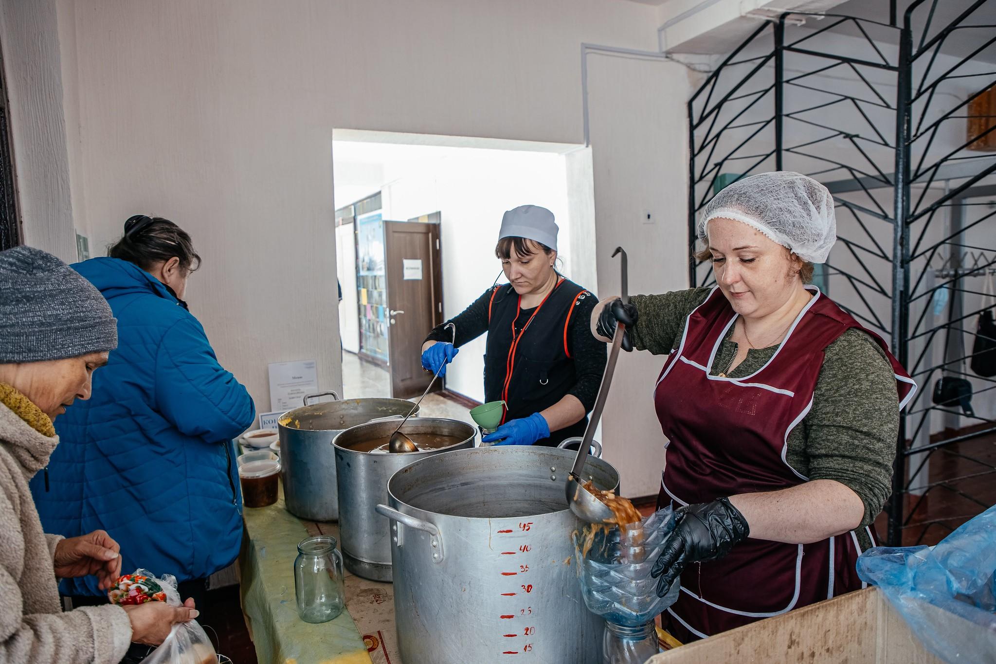 A woman distributes soup in one of the "heating points" in Kharkiv that LWF supports.