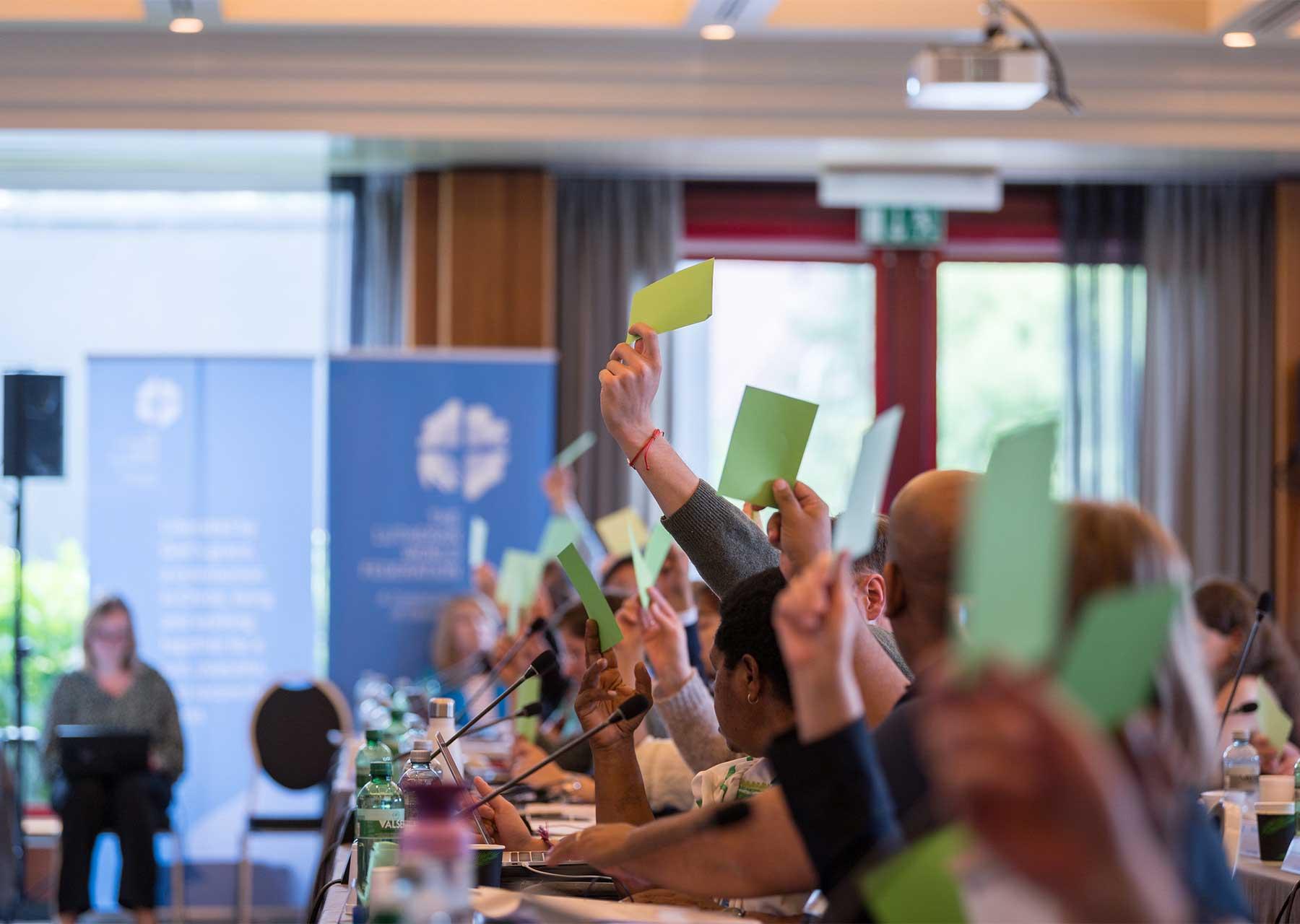 Council Members raise green cards to vote to approve a new LWF strategy for the period 2025-2031. Photo: LWF/Albin Hillert 