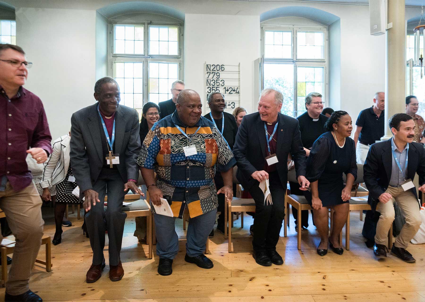 LWF President Bishop Henrik Stubkjær and other Council members join in singing and dancing during vibrant Sunday worship at the Evangelical Lutheran Church of Geneva. Photo: LWF/A. Hillert 