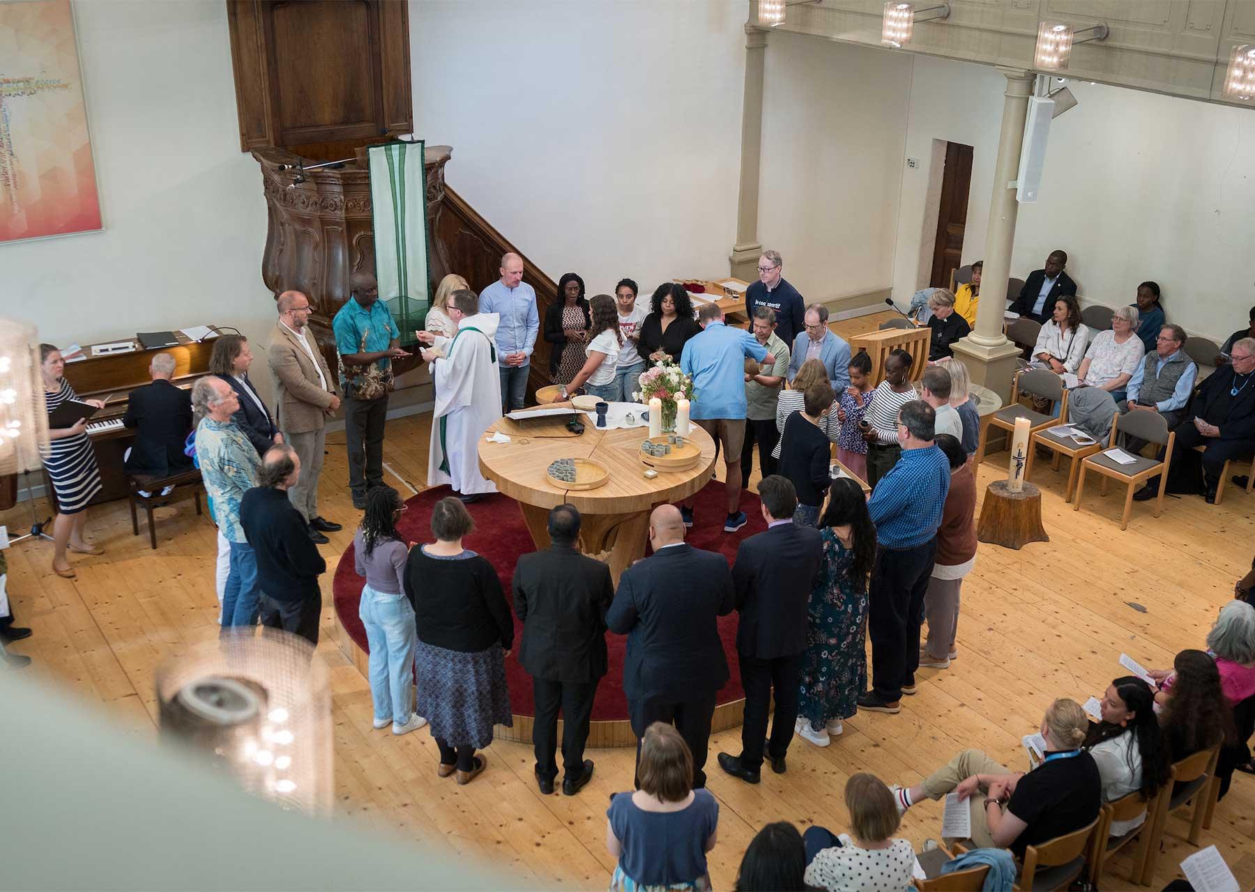 LWF Assistant General Secretary for Ecumenical Relations, Prof. Dirk Lange distributes Holy Communion as Council members join the local congregations of the Evangelical Lutheran Church of Geneva for Sunday worship. Photo: LWF/A. Hillert