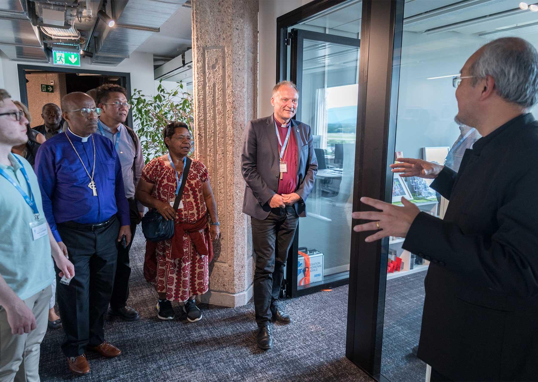 Mitarbeitende des Büros der Kirchengemeinschaft begrüßen LWB-Präsident Henrik Stubkjær und Ratsmitglieder in den neuen Räumlichkeiten nahe dem Genfer Flughafen