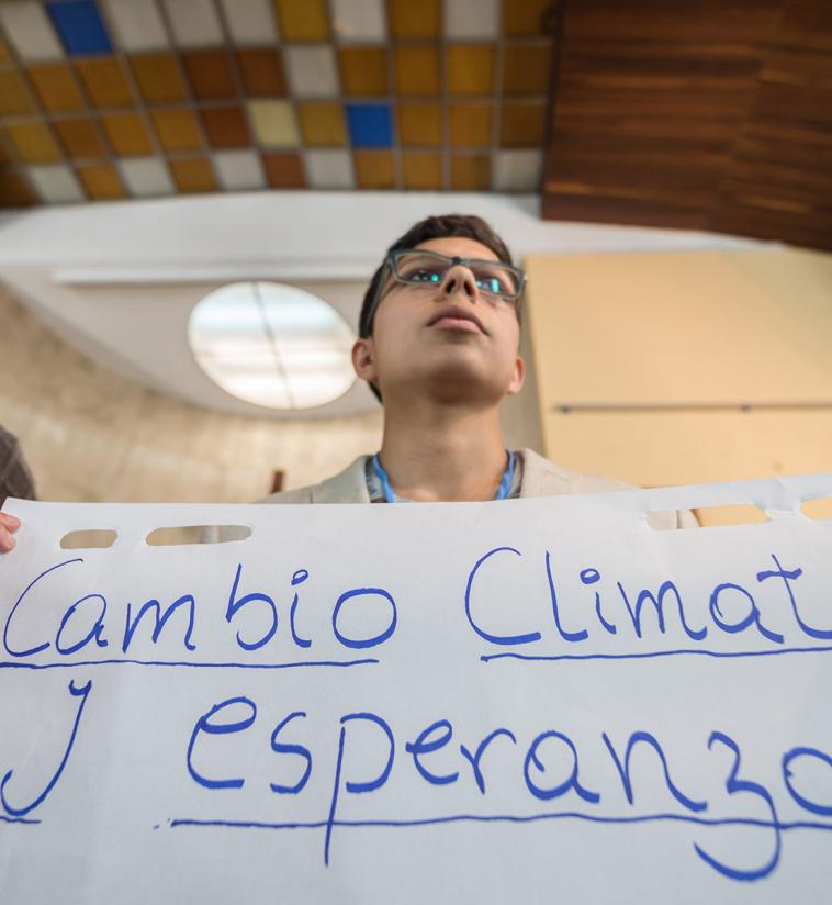 "Cambio Climático y Esperanza" (Climate Change and Hope): LWF delegate Sebastian Ignacio Muñoz Oyarzo from the Evangelical Lutheran Church in Chile holds a sheet of paper presenting a key discussion point from a gathering of faith representatives at an interfaith dialogue and prayer service on the eve of the United Nations Climate Change Conference (COP25) in Madrid, Spain. Photo: LWF/Albin Hillert