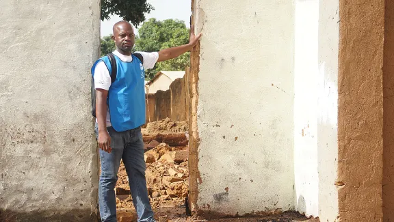 Armand Yabinti, community outreach officer for the LWF emergency program in CAR, outside the ruins of his house in Bohong village, Ouham PendÃ© prefecture.  Photo: LWF/P. Mumia