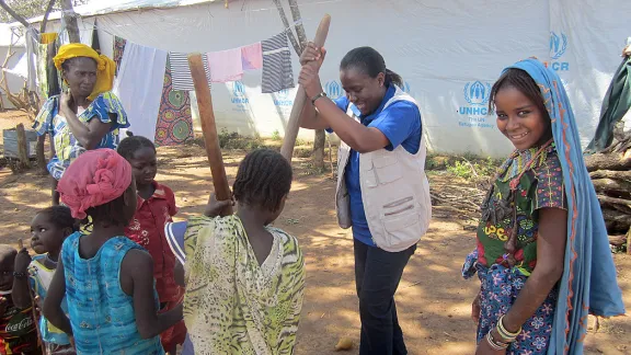 LWF team leader in Cameroon helping women and children prepare food. Photo: LWF Cameroon