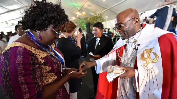 10 May 2017, Windhoek, Namibia: Bishop Ernst Gamxamub from the Evangelical Lutheran Church in the Republic of Namibia distributes bread during Holy Communion at the opening worship of the Lutheran World Federation's Twelfth Assembly.  Photo: LWF/Albin Hillert