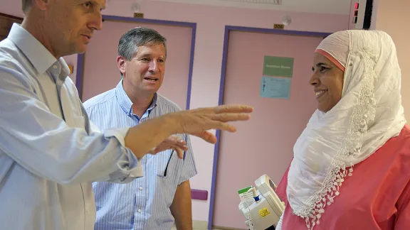 LWF General Secretary Rev. Martin Junge (left) and the Middle East program representative Rev. Mark Brown talk with AVH pediatric nurse Shadja Nasser. Photo: LWF/Thomas Ekelund