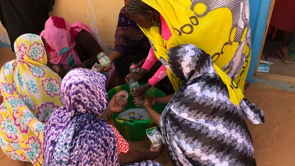 Women wash glasses to preserve vegetables in. Photo: LWF/ P. Lo Moro