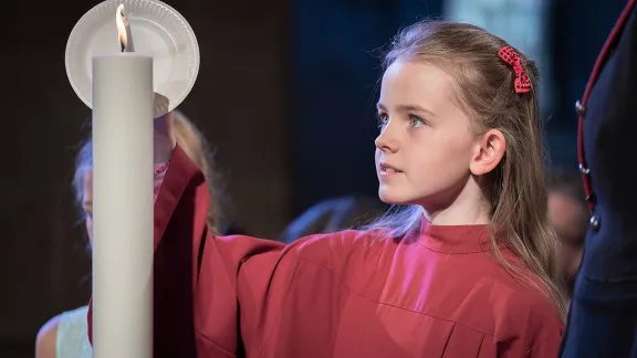 Im Dom zu Lund entzündet ein Mädchen eine Kerze, die symbolisch für einen der fünf ökumenischen Imperative steht. Foto: LWB/Albin Hillert