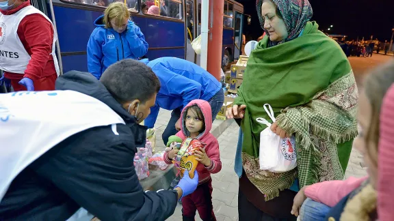 Mitarbeitende der Hungarian Interchurch Aid, einem Mitglied der ACTAlliance, kümmern sich um neu angekommene Flüchtlinge an der Grenze zwischen Ungarn und Kroatien. Hunderttausende durchquerten Ungarn in 2015, um von Syrien, Irak und anderen Ländern nach Westeuropa zu gelangen. Foto: Paul Jeffrey/ACT