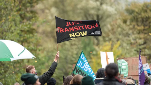 âJust transition nowâ reads a flag waving in the wind. Thousands of people joined a march through Glasgow city center, calling for climate justice and world leaders to address the climate emergency at COP26. Photo: LWF/Albin Hillert