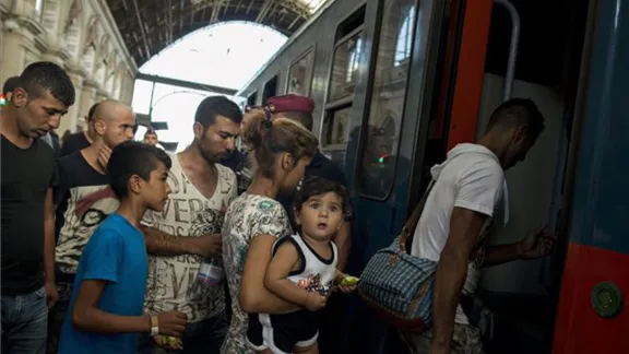 A refugee woman carrying a child prepares to board a train for northern Europe at Budapest's main station, Keleti.Photo: MTI