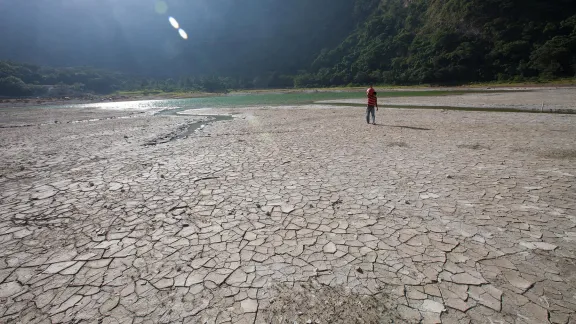 At the lagoon of AlegrÃ­a, UsulutÃ¡n, El Salvador, water levels have dropped dramatically in the drought that is affecting the region. Here, where the water has receded hundreds of meters, a man carries a âcantaroâ of water across the dry lagoon bed. The effect of climate changes in the Central American region are already extreme. Photo: LWF/Sean Hawkey