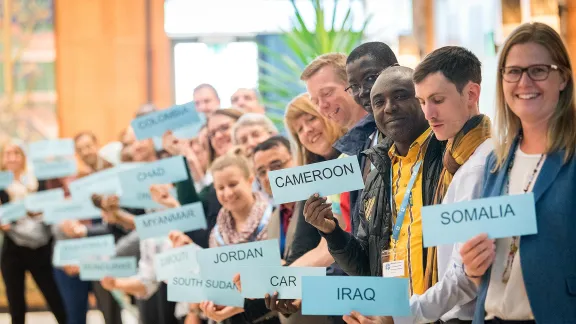 World Service staff attending the GLTM hold the names of the countries where they are working. Photo:LWF/A. Hillert