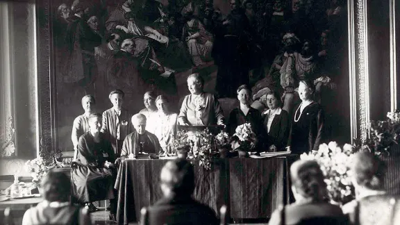 Paula Müller-Otfried (Bildmitte, stehend) war die erste Frau, die ab 1921 in zur Landessynodalen der Evangelisch-Lutherischen Landeskirche Hannovers gewählt wurde. Die streitbare Frau nahm 1919 an den Wahlen zur Weimarer Nationalversammlung teil und erhielt 1920 einen Sitz im Reichstag. Foto im Auftrag des DEF: Kasch, A.; Th. Möller Nachf., Stralsund; AddF, Kassel, Sign.: NL-K-16, D-F1/00045.