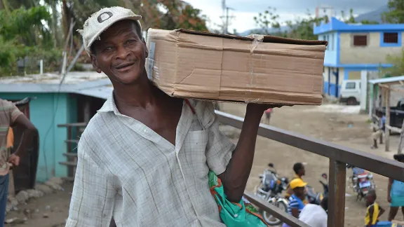 A man receives a shelter kit in a joint LWF/Diakonie Katastrophenhilfe distribution in Petit Goave. Photo: LWF Haiti