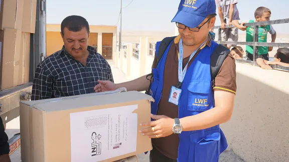 LWF assisting in the distribution of winter clothes sponsored by the Evangelical Lutheran Church of Bavaria in Khanki camp, Northern Iraq. Photo: LWF Iraq