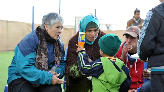 LWB-Vizepräsidentin Gloria Rojas Vargas scherzt mit Ahmad, einem syrischen Flüchtlingsjungen, in der LWB-Friedensoase. Foto: LWB/ C. Kästner