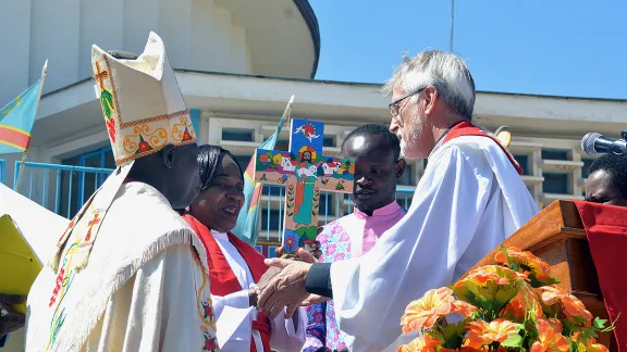 LWB-Generalsekretär Junge überreicht der Festgemeinde der ELCCo ein Kreuz, das vom salvadorianischen Künstler Christian Chavarría gefertigt wurde. Foto: LWB/Gracia Rubango