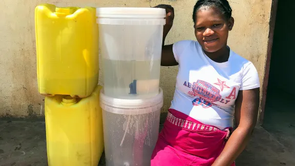 Zikhai Suela from Mpengo Village shows the water filters and gallons distributed by LWF. Photo: LWF/B. Khanal 