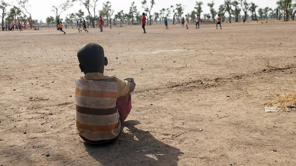 A little boy watches a football game in a child friendly space, Gendrassa refugee camp, South Sudan. Photo: LWF/ C. KÃ¤stner